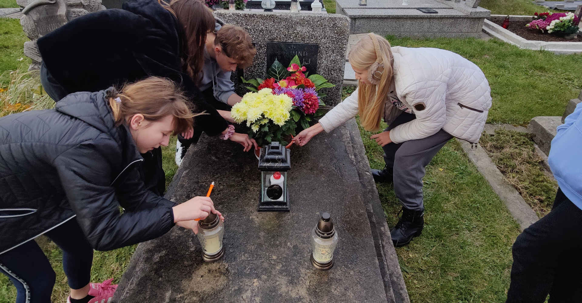 Uczniowie na cmentarzu sprzątają pomnik